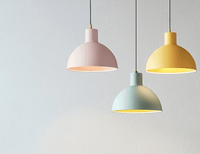 Drei leuchtende Hängelampen in hellrosa, hellblau und hellgelb vor einer weißen Wand